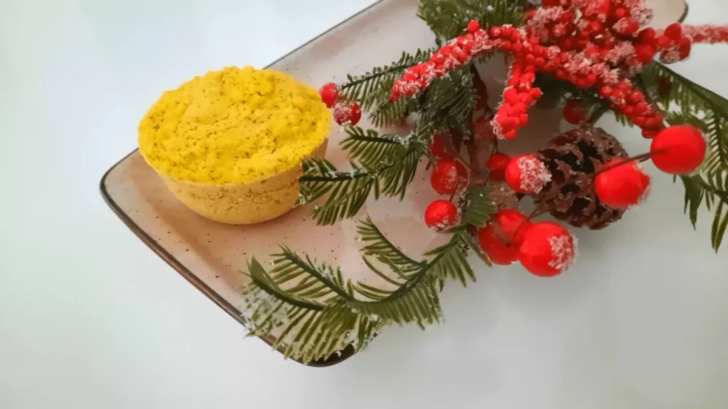 Bolo de laranja em caneca com arranjos florais de natal, travessa beje e colorido vermelho