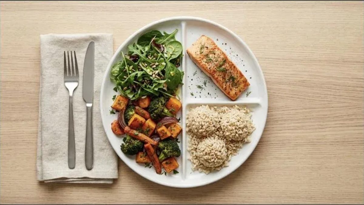 Prato dividido com legumes assados, salada, salmão grelhado e arroz integral